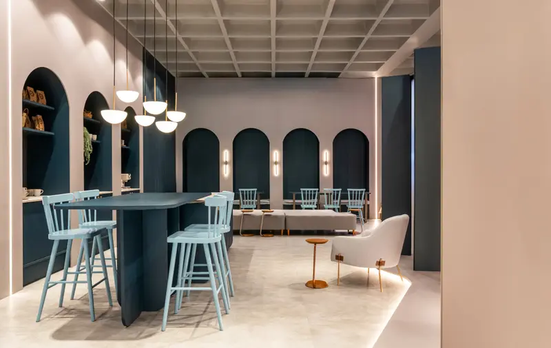 Espaço gourmet com nichos em arco azul e banquetas