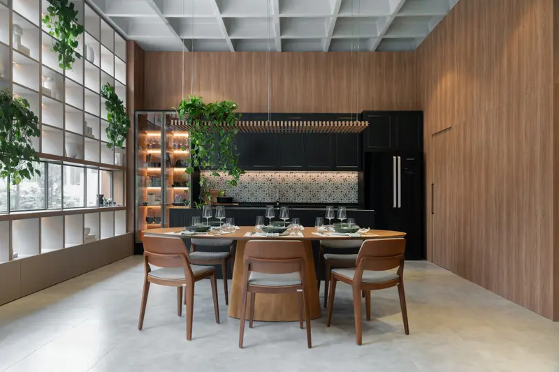 Sala de jantar integrada a uma cozinha preta com cristaleira iluminada