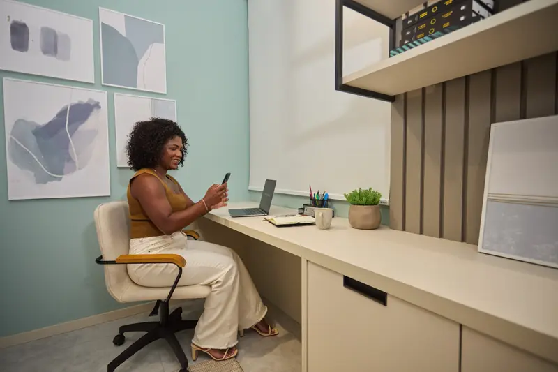 Home office planejado com bancada clara e parede verde-água